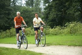 Active senior couple biking in the park.
